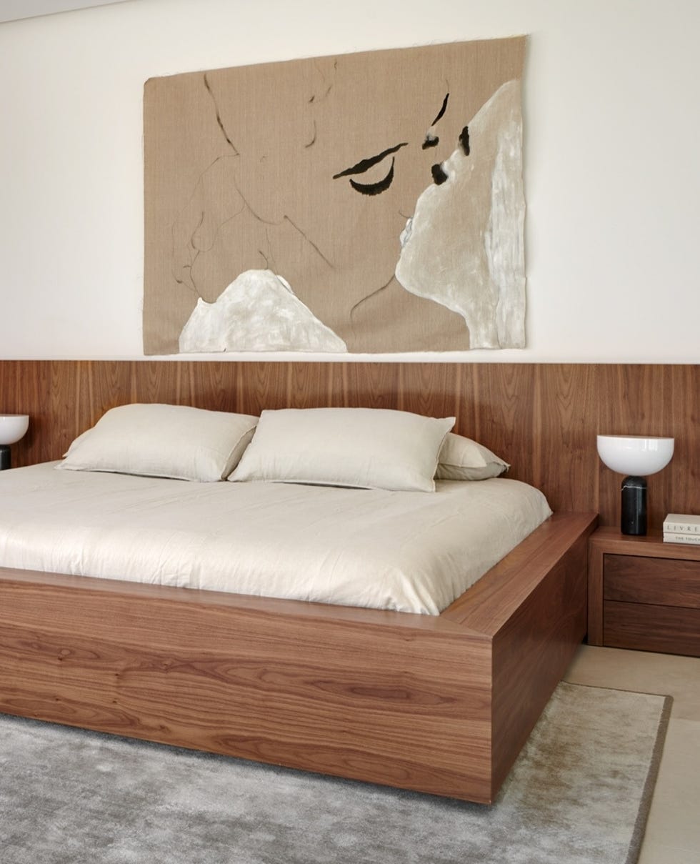 modern bedroom featuring a large artwork above the bed and wooden furniture