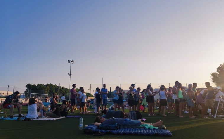 Imagen principal - Niños asomados a los telescopios, colas de curiosos siguiendo las explicaciones de los voluntarios y las gafas solares listas para observar al Sol en el polideportivo de Inca