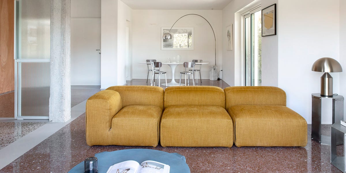 Esta casa de 160 m2 de estilo moderno y minimalista se distribuye gracias a un gran mueble de madera y a una cocina semiabierta