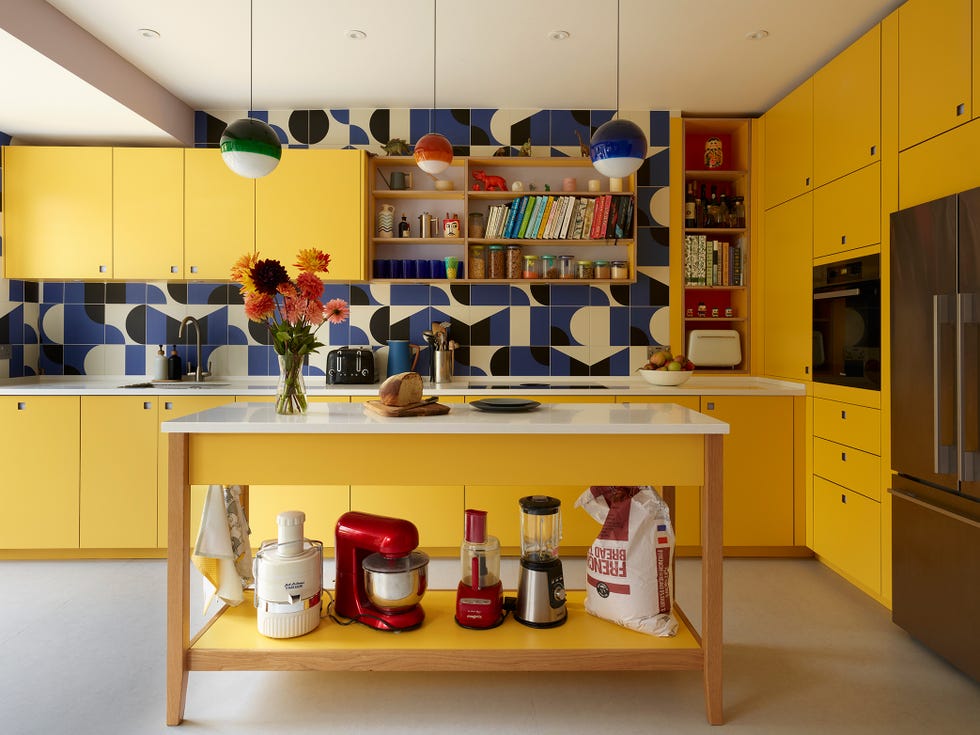bright yellow kitchen with blue, black and white graphic tiling as a splashback