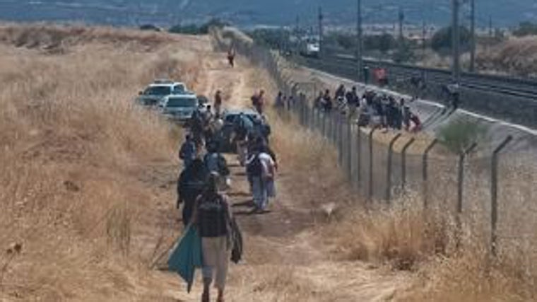 Los pasajeros afectados caminan paralelos a las vías