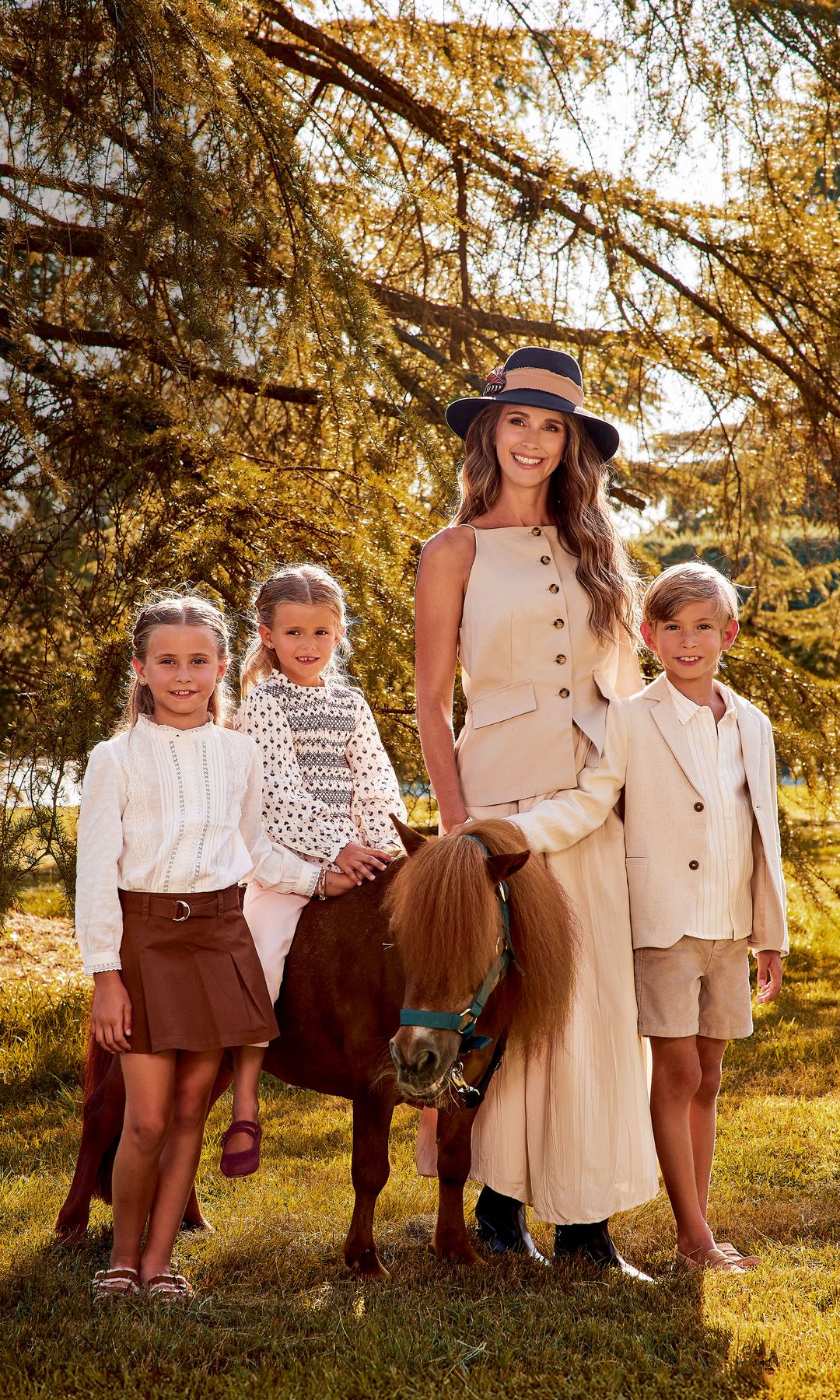 "Markuss se parece muchísimo a Carlos. Yo creo que las niñas se parecen un poco a mí, pero siempre digo que son una versión mejorada cien por cien", nos dice Astrid, junto a estas líneas, con vestido de Zara, botas de Pedro del Hierro, joyas de Aristocrazy y sombrero de Mimoki. El "blazer" de Markuss es de Nanos y los mocasines, de Coconut El Corte Inglés; los zapatos de Liene son de Birkenstock, y los de Álisse, de Coconut El Corte Inglés