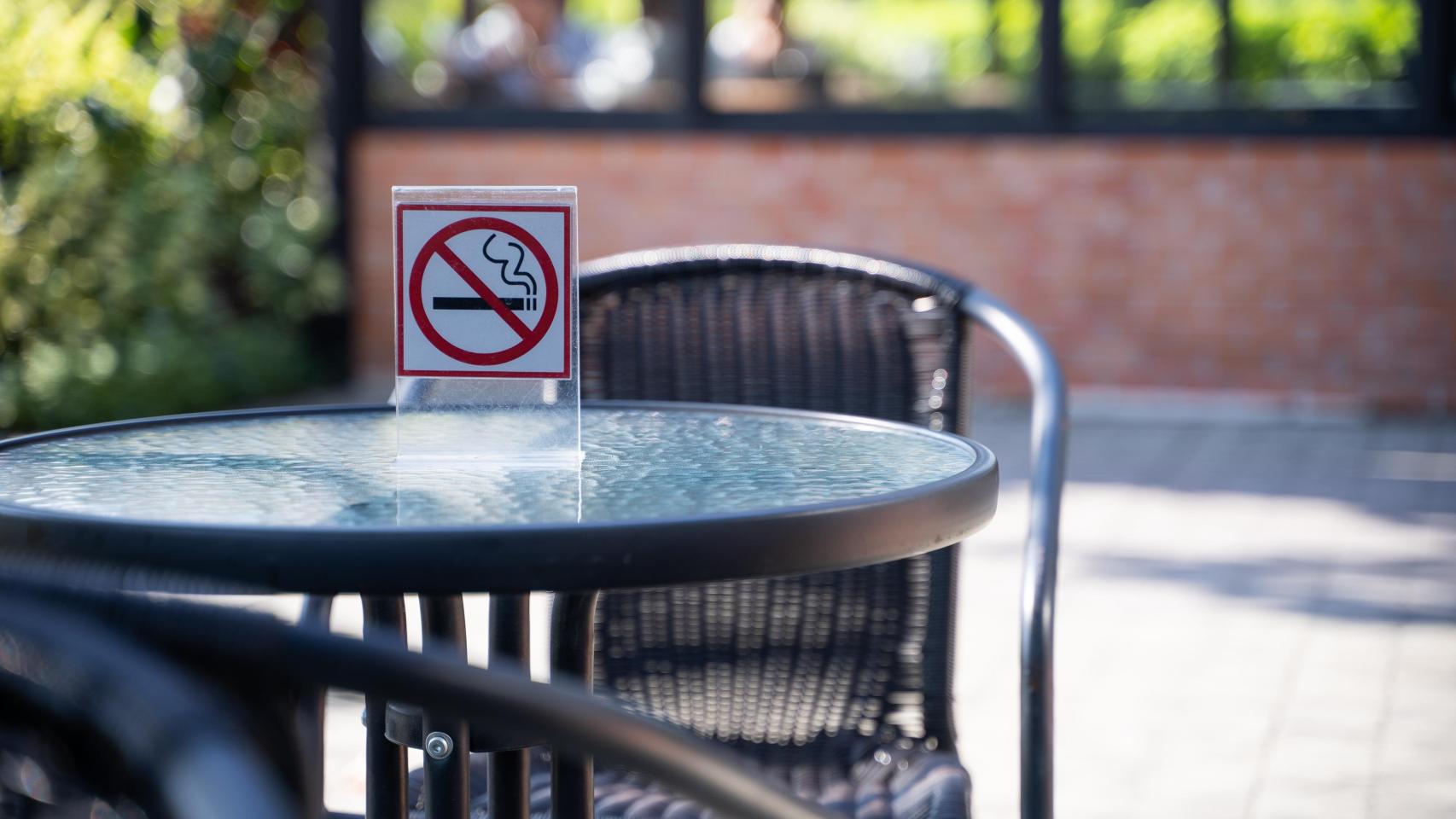 Una mesa en una terraza con el letrero de