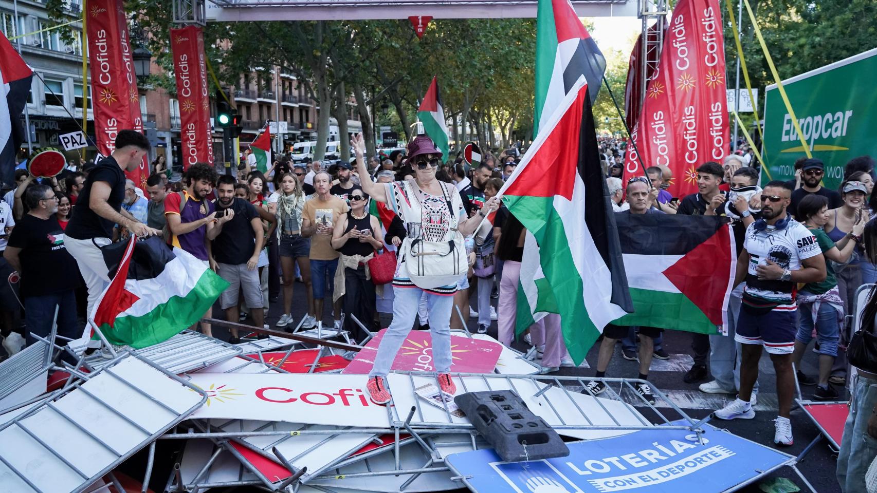 Manifestantes contra Israel bajo la pancarta del último kilómetro de la etapa.