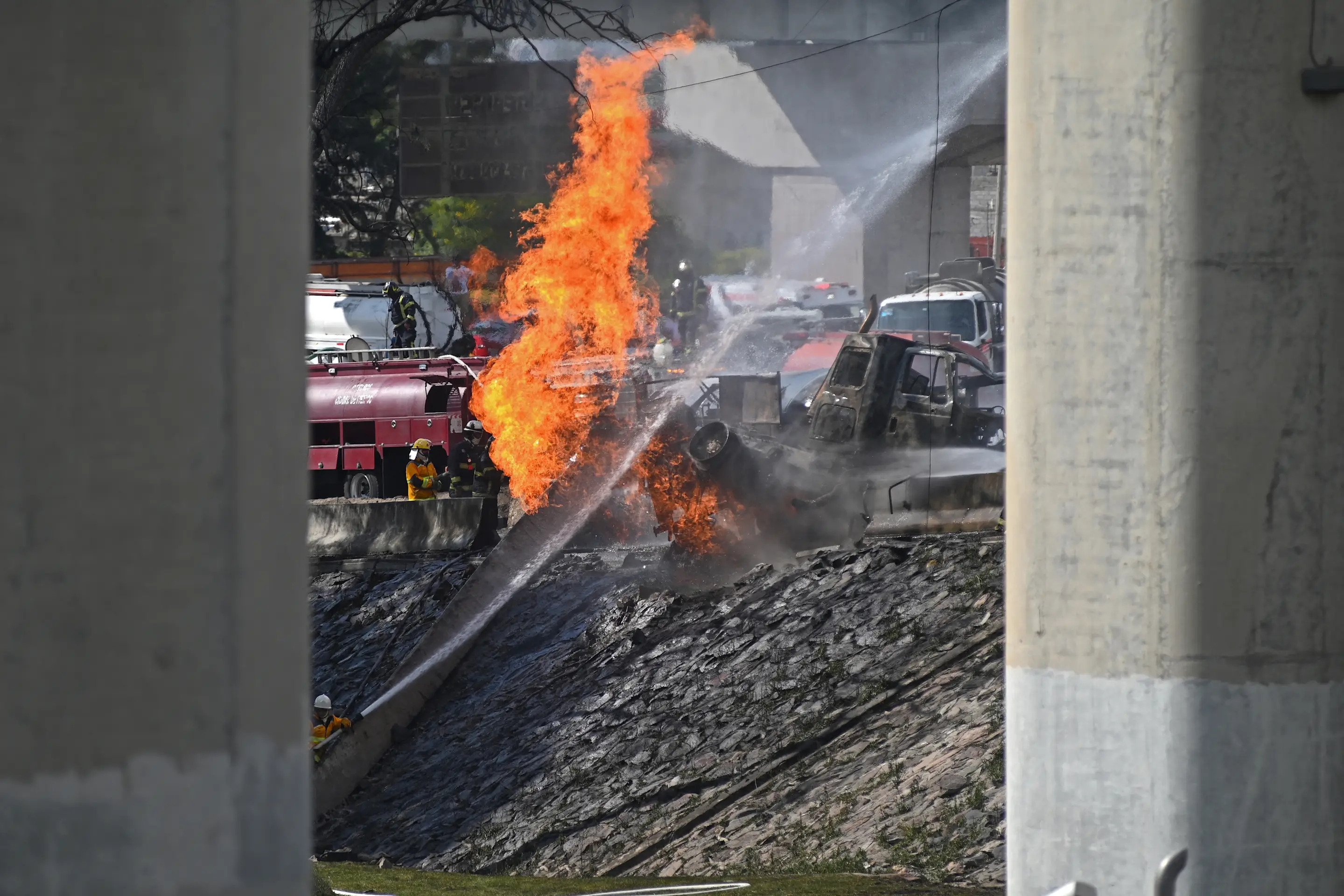 Mexican firefighters extinguish the flames of a gas truck that exploded in Mexico City on September 10, 2025. Nearly 60 people were wounded, 19 gravely, when a gas truck exploded in Mexico City on September 10, 2025, causing widespread damage, municipal officials said. (Photo by Valentina Alpide / AFP) (Photo by VALENTINA ALPIDE/AFP via Getty Images)          