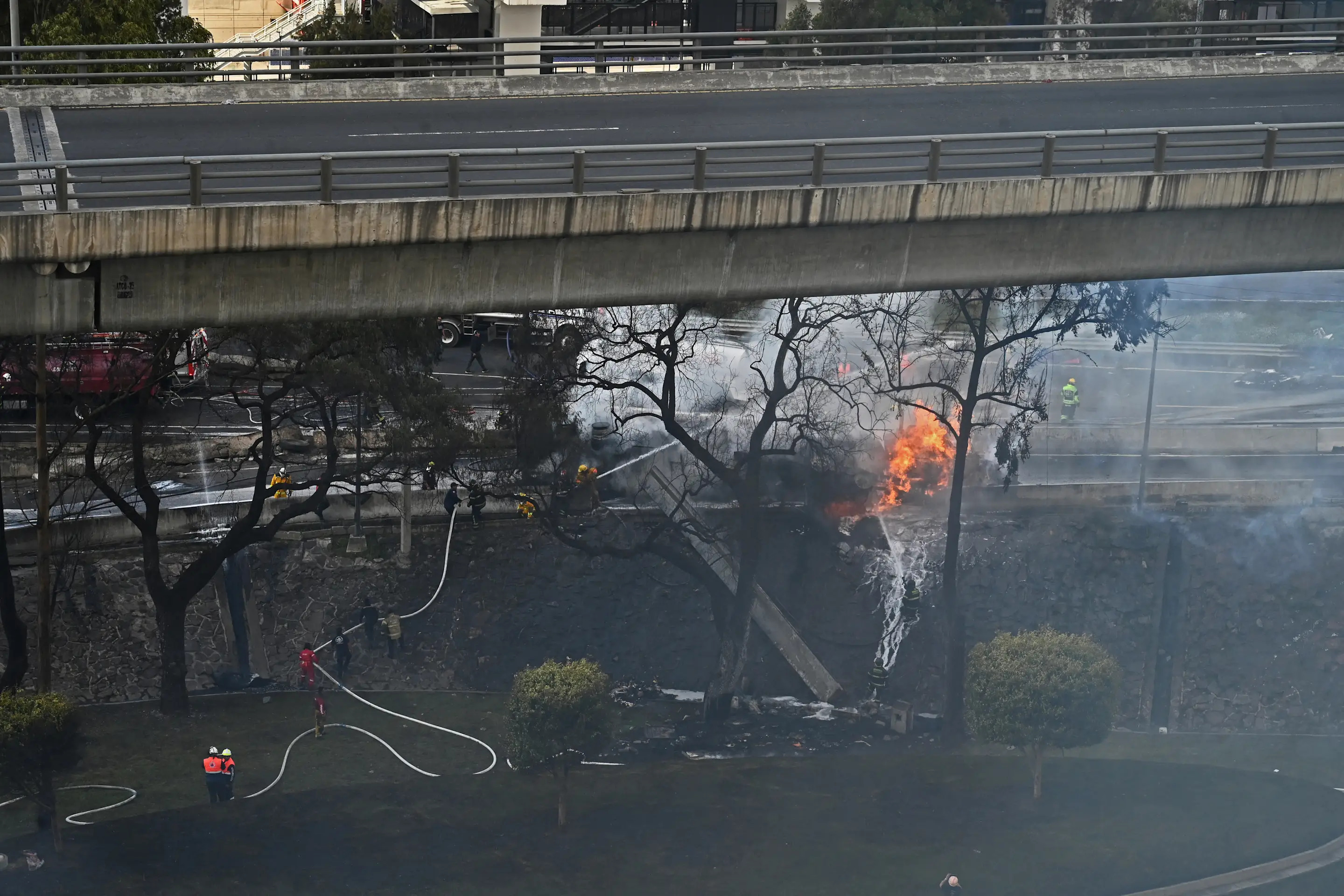 Mexican firefighters extinguish the flames of a gas truck that exploded in Mexico City on September 10, 2025. Nearly 60 people were wounded, 19 gravely, when a gas truck exploded in Mexico City on September 10, 2025, causing widespread damage, municipal officials said. (Photo by Valentina ALPIDE / AFP) (Photo by VALENTINA ALPIDE/AFP via Getty Images)          