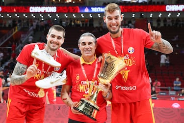 Sergio Scariolo posa con los hermanos Hernangómez con el título de campeones del mundo 2019. 