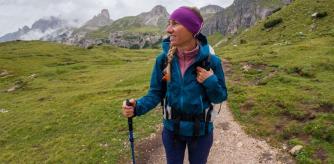 Una mujer practica senderismo en otoño con una chaqueta impermeable
