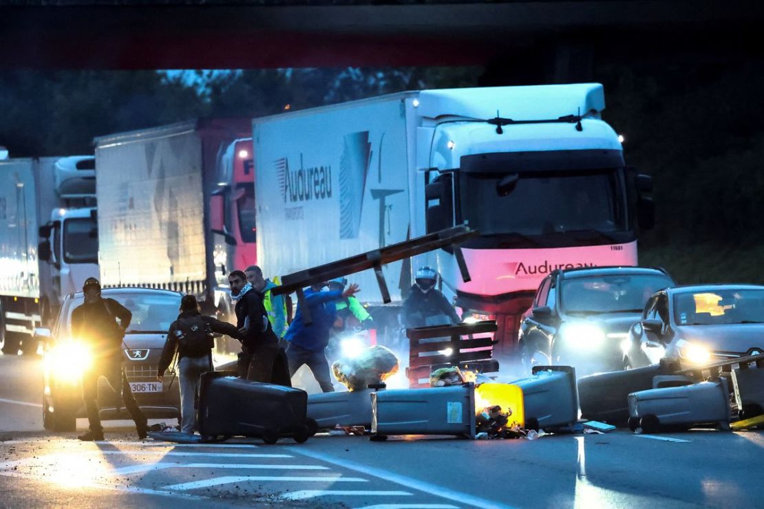 Manifestantes lanzan contenedores de basura y otros objetos para bloquear el tráfico en la circunvalación de Nantes como parte de las protestas 
