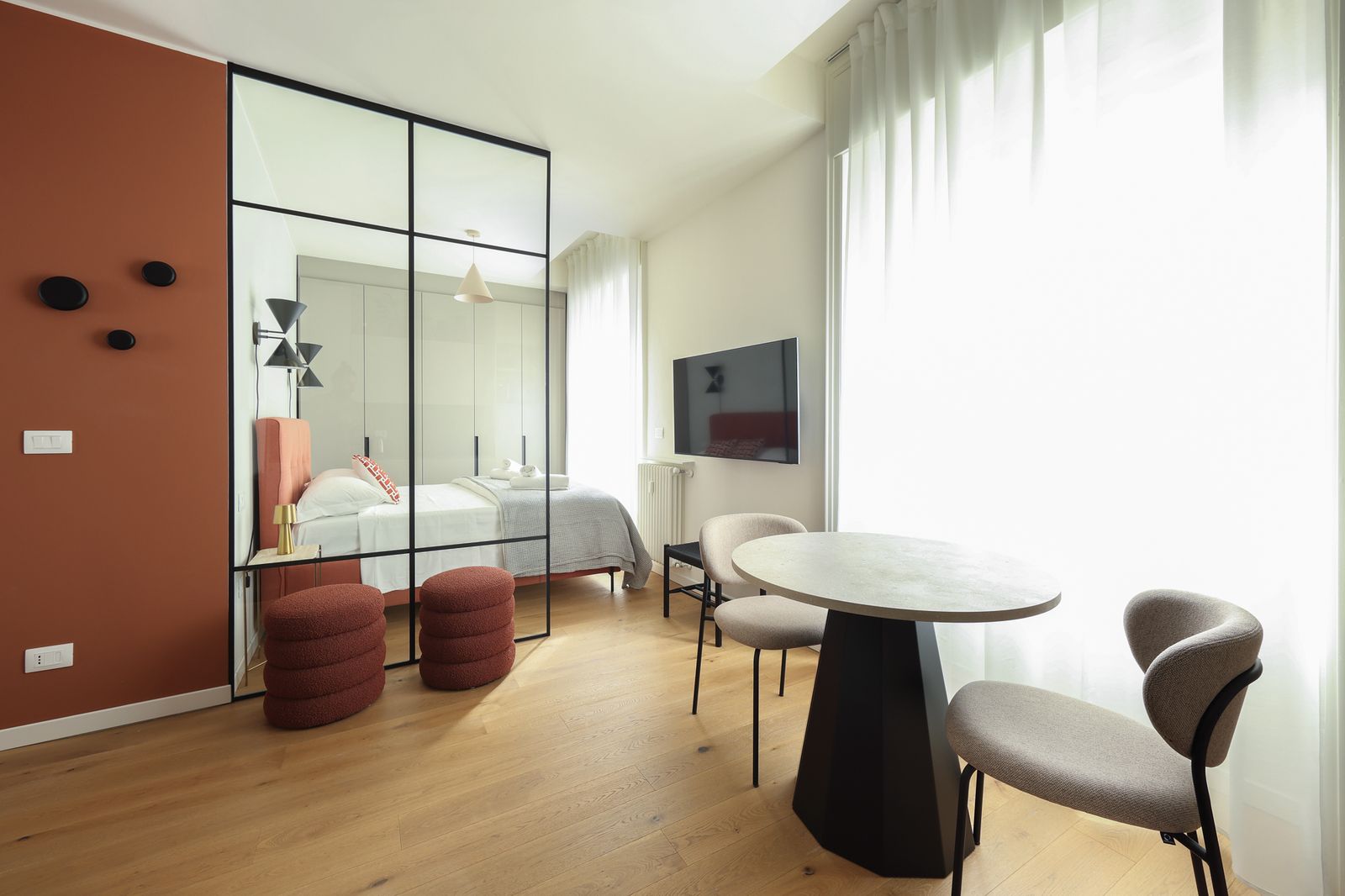 Habitación con pared naranja y cortinas blancas