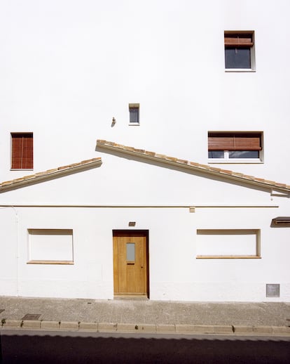 Vista de la fachada principal de la casa, que muestra la edificación original y la vivienda construida sobre su cubierta.