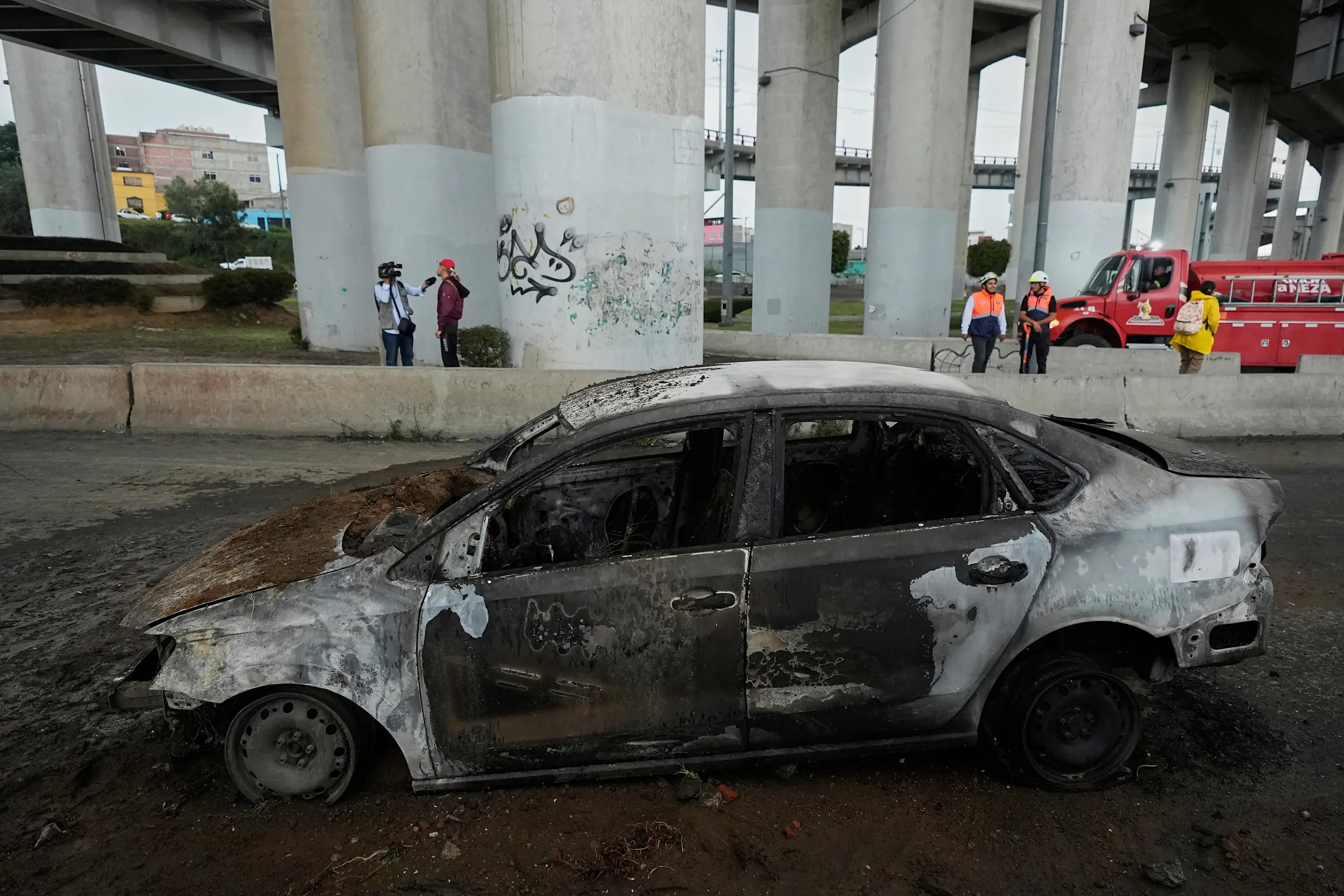A burned car sits below an underpass following a gas tanker explosion in Mexico City, Wednesday, Sept. 10, 2025. (AP Photo/Fernando Llano)