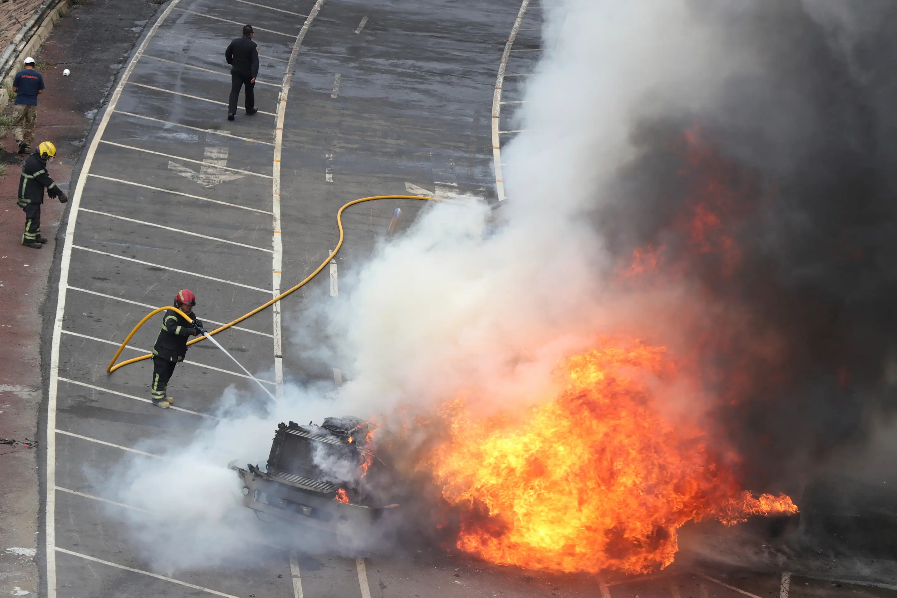 A firefighter extinguishes a fire after a gas tanker exploded under a highway overpass in Mexico City, Wednesday, Sept. 10, 2025. (AP Photo/Tristan Velazquez)