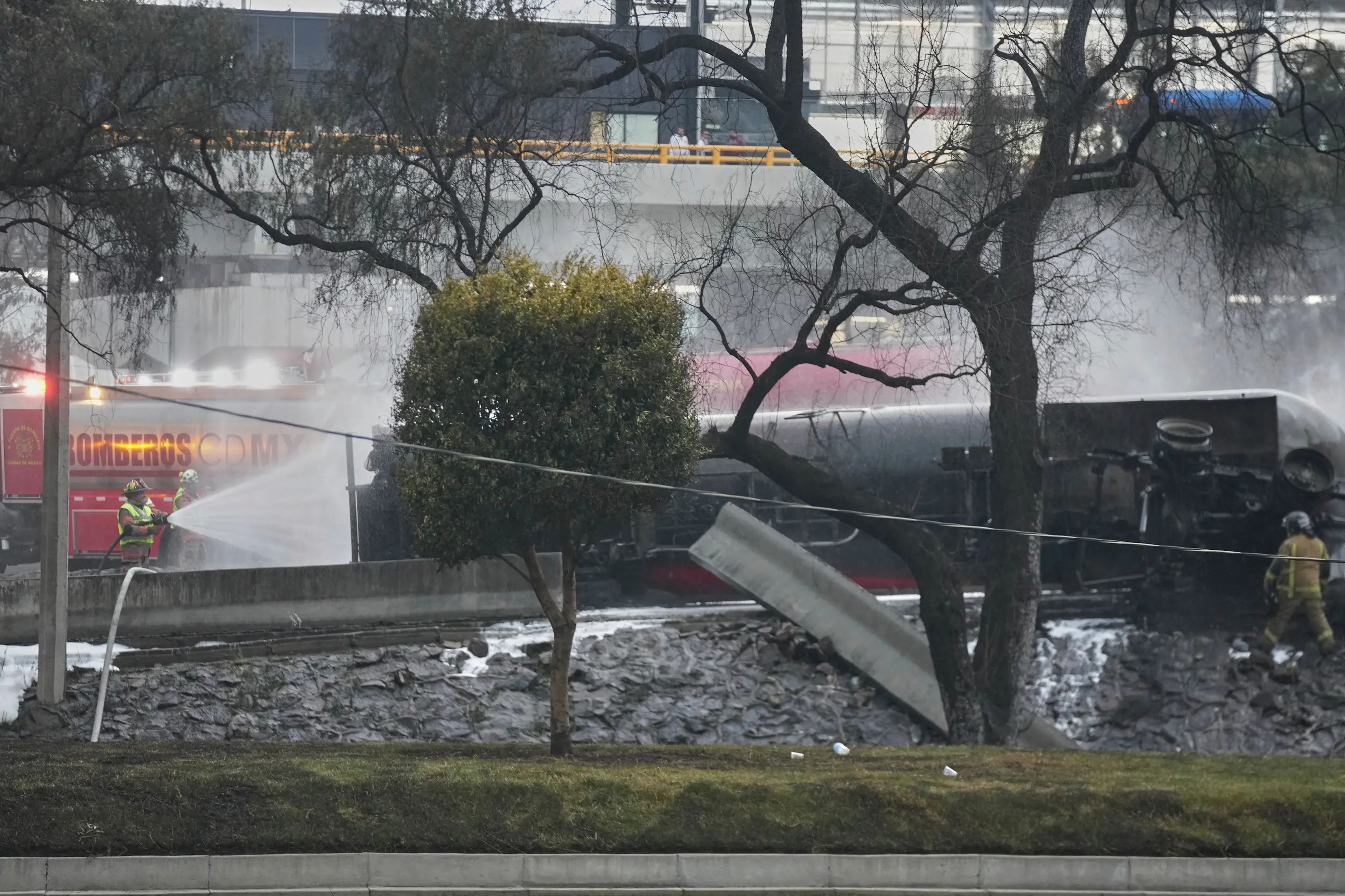 Firefighters spray a hose at a gas tanker that exploded under a highway overpass in Mexico City, Wednesday, Sept. 10, 2025. (AP Photo/Fernando Llano)
