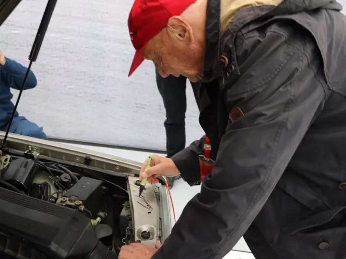 Niki Lauda firmando el Mercedes que era de Senna