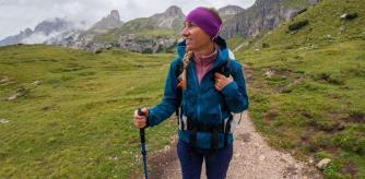 Una mujer practica senderismo en otoño con una chaqueta impermeable