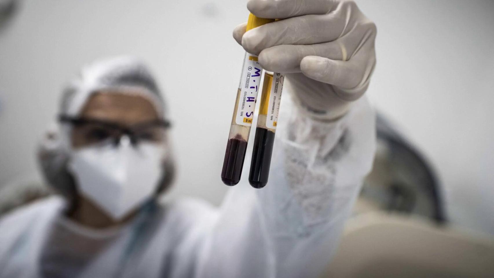 Un investigador sostiene unas muestras de sangre.