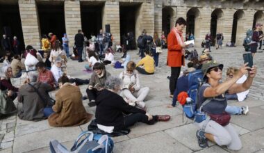Una peregrina se hace un selfie junto la varias personas en plena lectura coral.