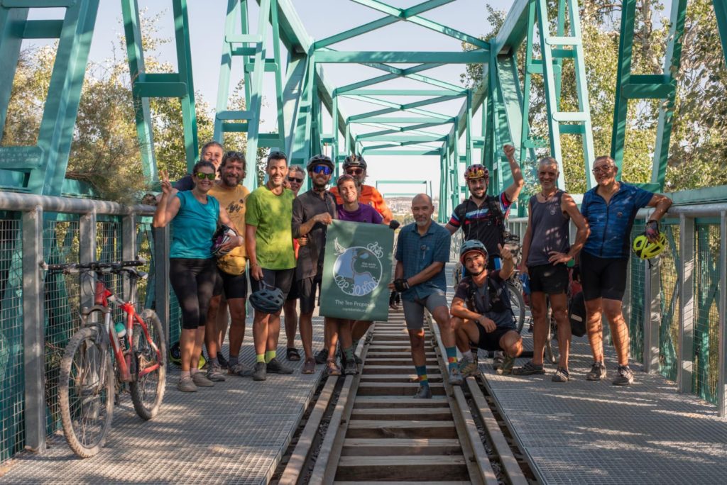 La COP30 Bike Ride, junto a miembros de Rivas Respira, a su llegada a Rivas, en el puente de Arganda 