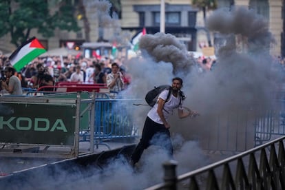 Un manifestante lanza un bote de humo durante la protesta  propalestina en Madrid. 