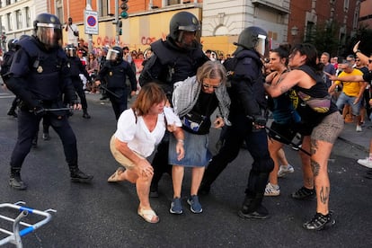 Una mujer es ayudada a levantarse del suelo tras una carga policial en Madrid, durante la celebración de la Vuelta. 