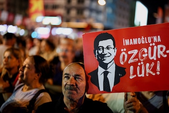 Un hombre sostiene un cartel