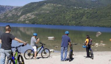 Un grupo de personas en bicicleta en una de las playas del Lago de Sanabria.