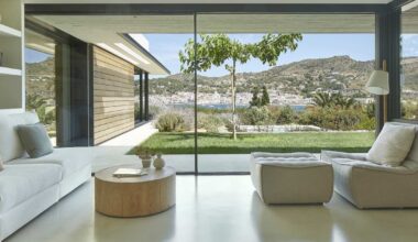 Esta casa en el Alto Ampurdán resuelve la tensión entre la carretera y las vistas al mar gracias a un jardín abierto lleno de arbolados