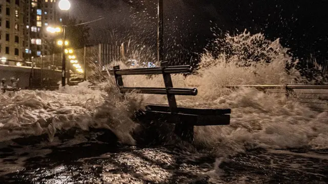 El mar golepa un banco situado en un paseo marítimo.
