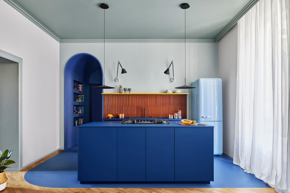 una cocina azul de una casa con colores fuertes, arte y decoracion moderna