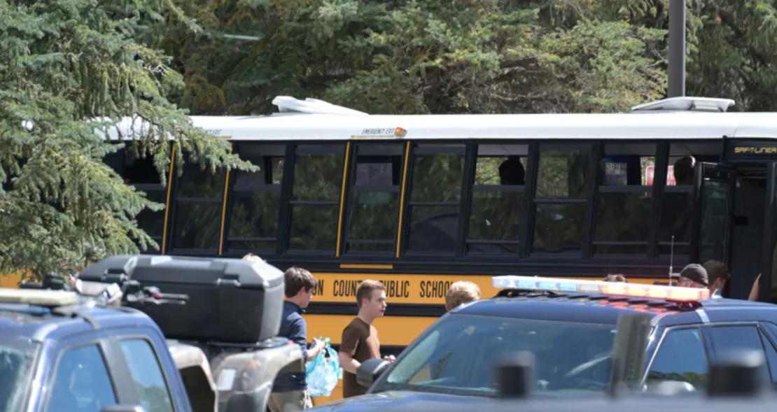 Los estudiantes suben a un autobús en medio de una fuerte presencia policial después de un tiroteo en la Escuela Secundaria Evergreen el miércoles.