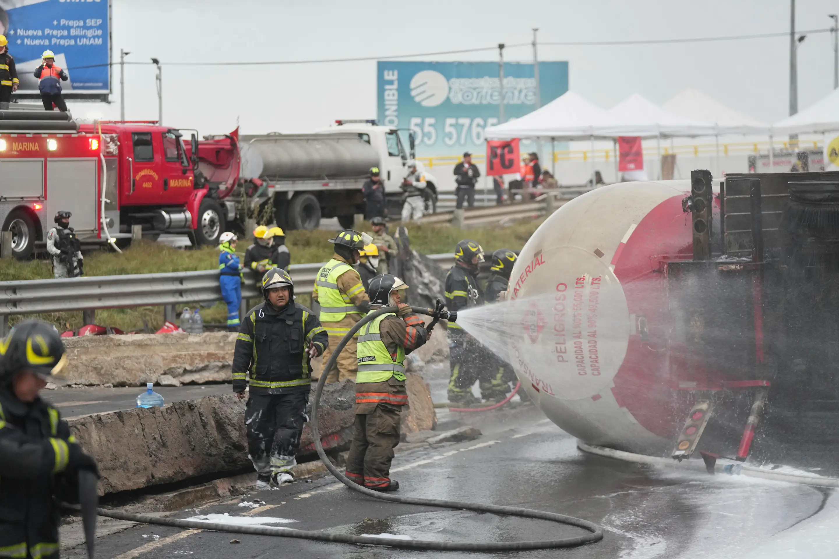 Firefighters spray a hose at a gas tanker that exploded under a highway overpass in Mexico City, Wednesday, Sept. 10, 2025. (AP Photo/Fernando Llano)