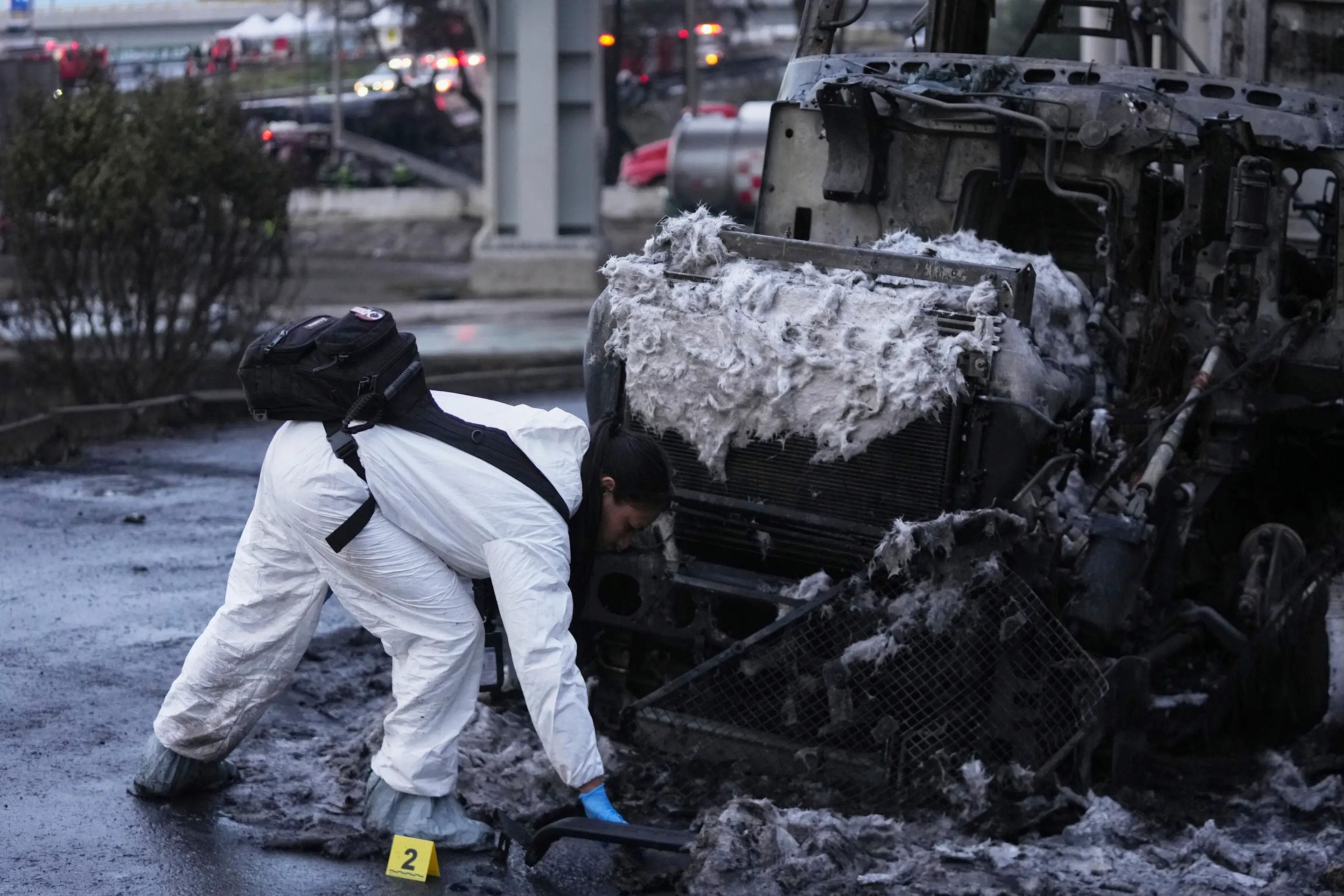 A forensic worker inspects a damaged truck after a gas tanker exploded under a highway overpass in Mexico City, Wednesday, Sept. 10, 2025. (AP Photo/Fernando Llano)