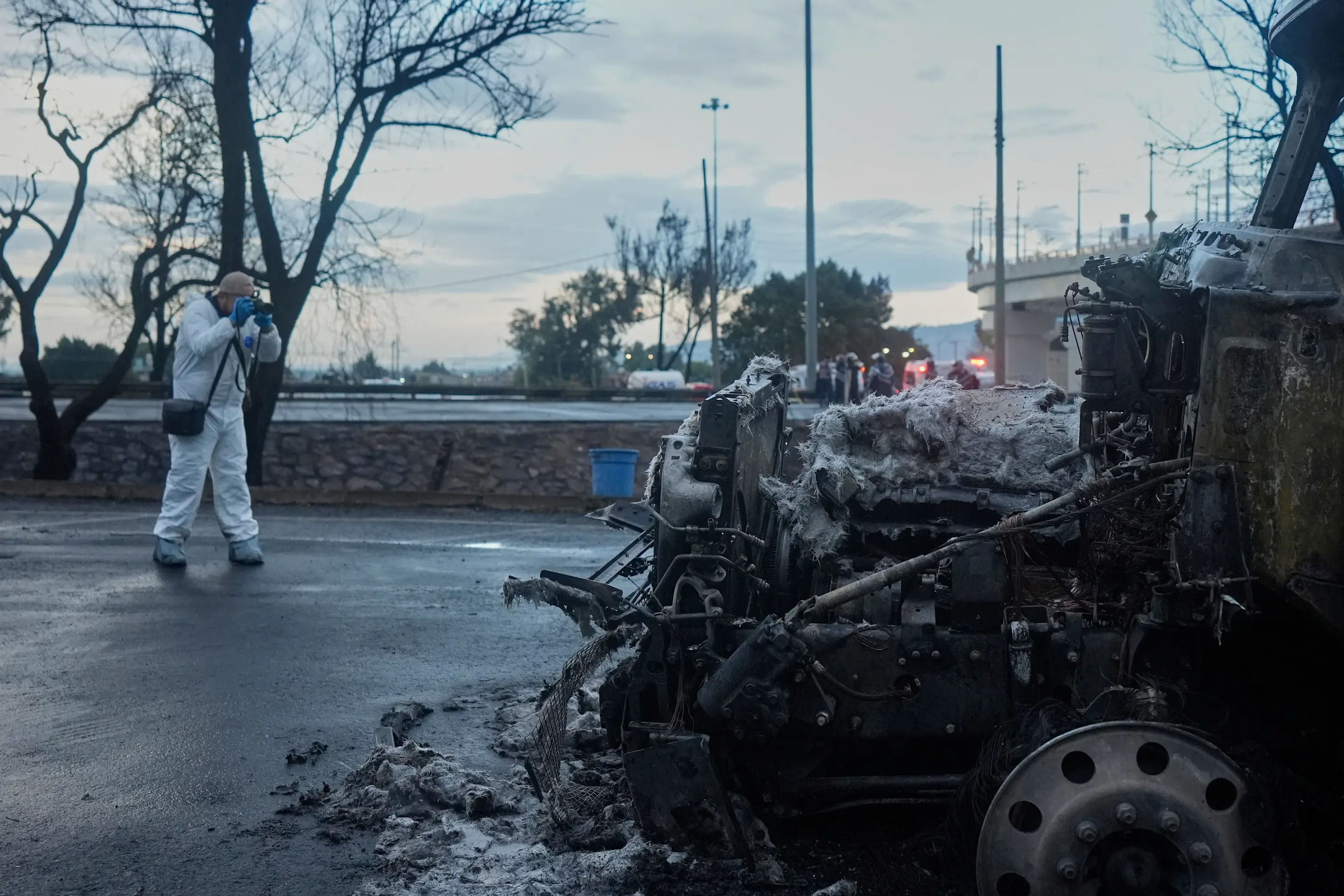 A forensic worker takes a photo of a damaged truck after a gas tanker exploded under a highway overpass in Mexico City, Wednesday, Sept. 10, 2025. (AP Photo/Fernando Llano)