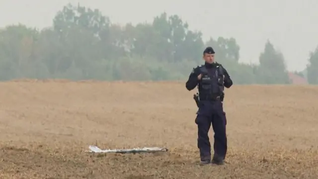 Un oficial polaco, junto a un dron en el suelo en Polonia. 