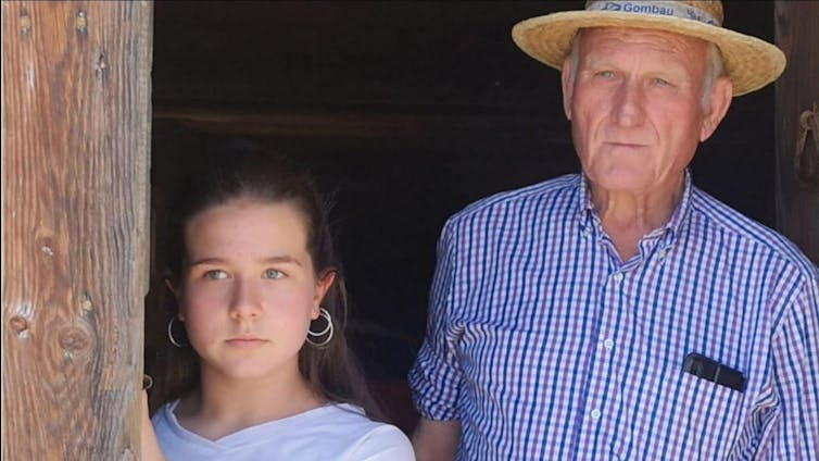 Una adolescente y un anciano observan algo fuera de cambo.