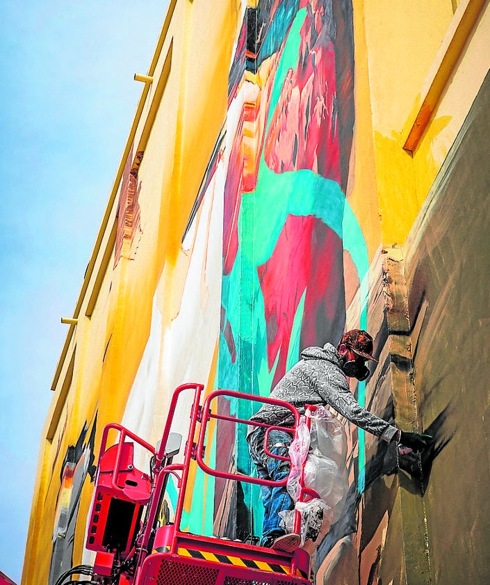 Imagen secundaria 2 - Icat y David Stone con su compinche pintan sus murales en diversos pueblos de Granada.