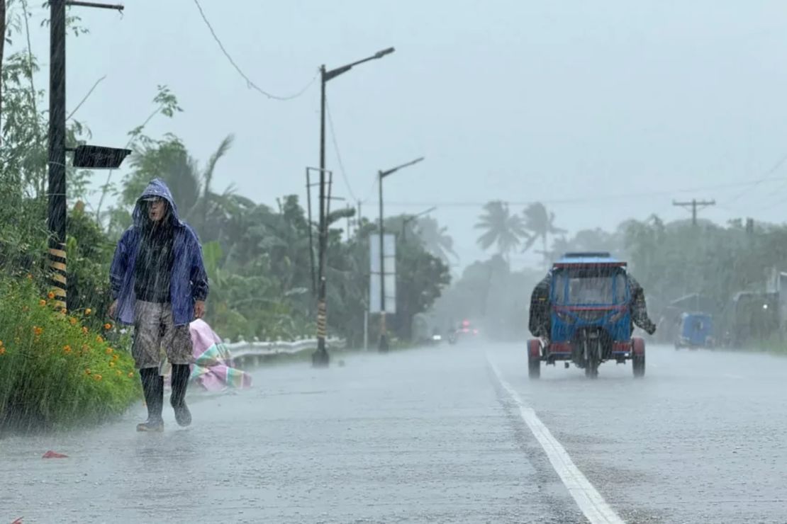Un hombre camina por una carretera en medio de fuertes lluvias debido al súper tifón Ragasa en la ciudad de Lal-lo, provincia de Cagayán, el 22 de septiembre de 2025.