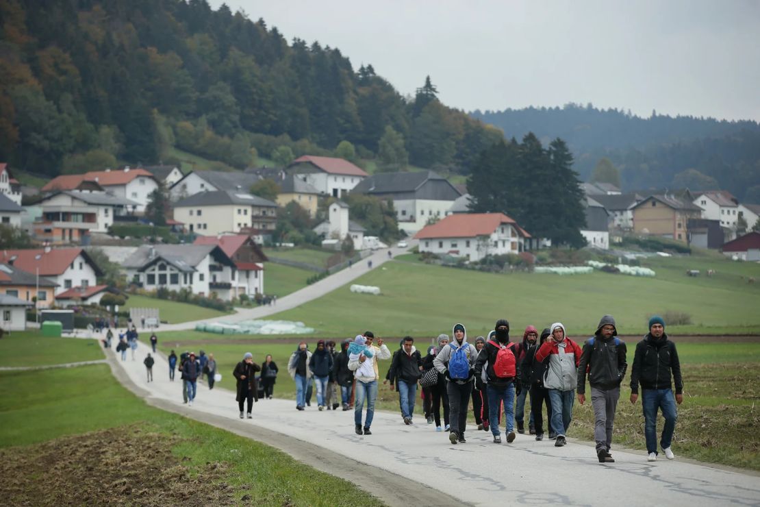 Migrantes que llegaron en autobuses alquilados por las autoridades austriacas caminan hacia la frontera con Alemania el 17 de octubre de 2015, cerca de Mistlberg, Austria.