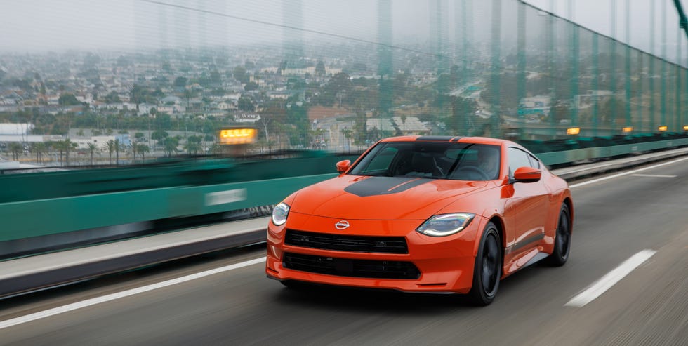 sports car in motion on a bridge with a city view in the background