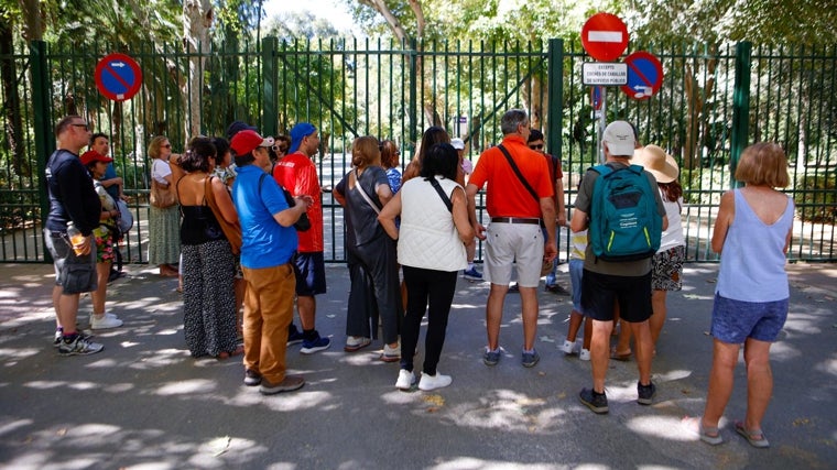 Numerosos turistas se topan con las puertas de entrada al Parque de María Luisa cerradas el pasado jueves