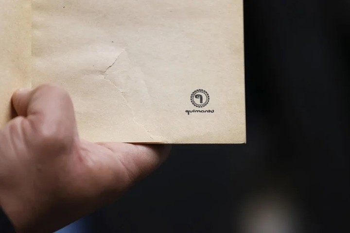 Una persona sostiene un libro con el sello de la editora estatal durante el gobierno de Allende, ‘Quimantú’, en el depósito de la Biblioteca Nacional, en Santiago (Chile). EFE/ Elvis González