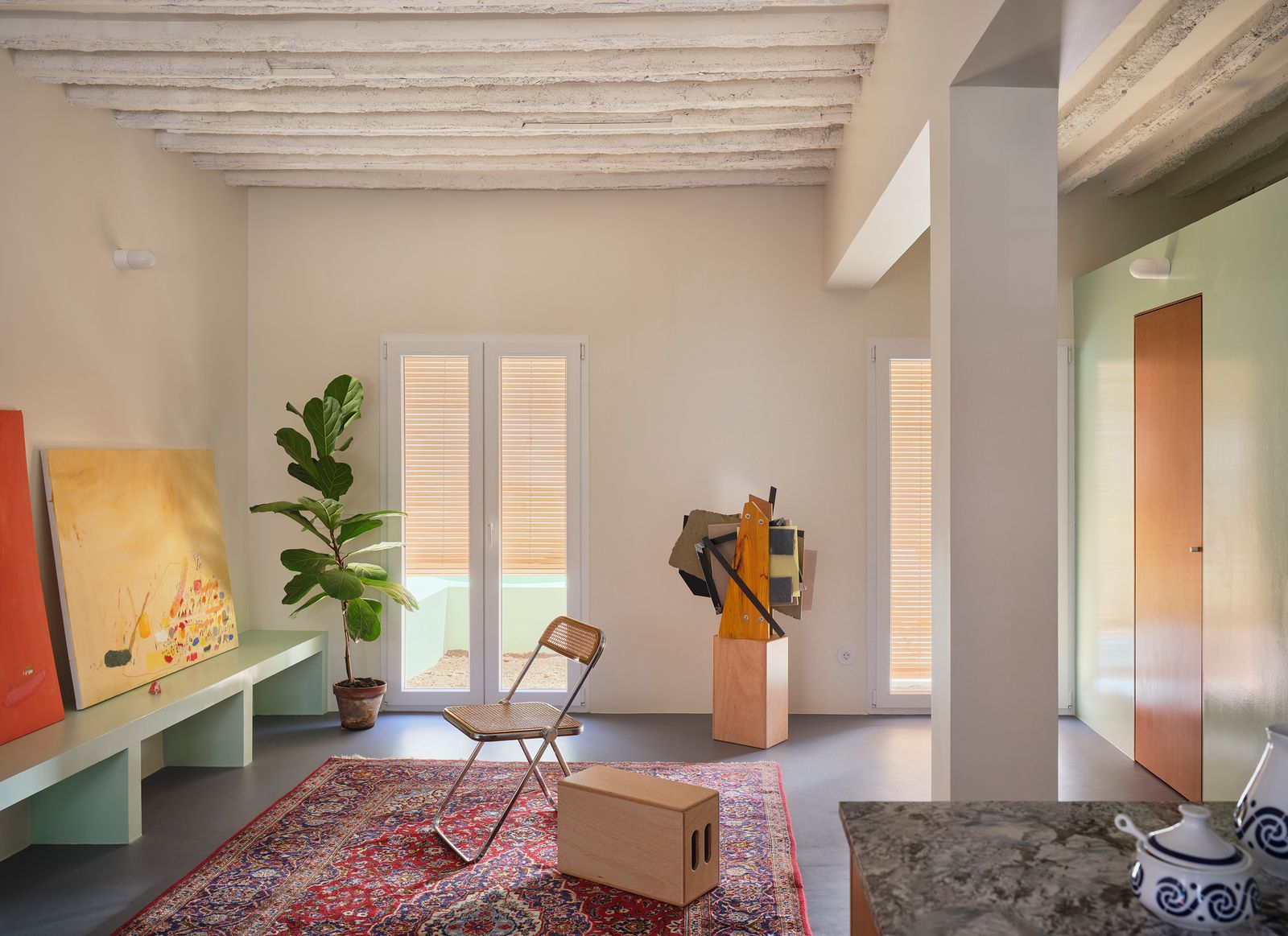 El verde articula toda la planta baja y conecta interior y exterior en un gesto continuo. En el centro de la imagen...