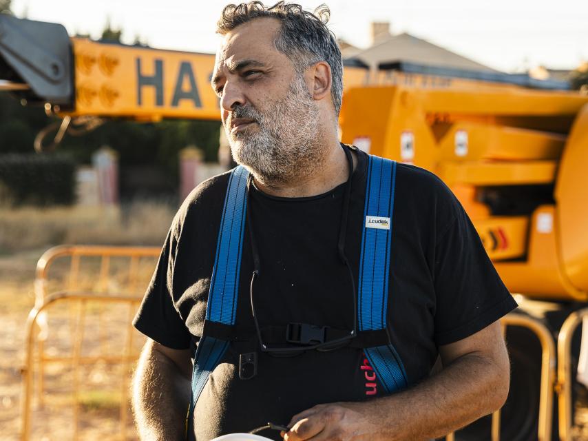 El pintor Manuel León con el arnés puesto para subirse a la grúa desde donde está pintando el mural.