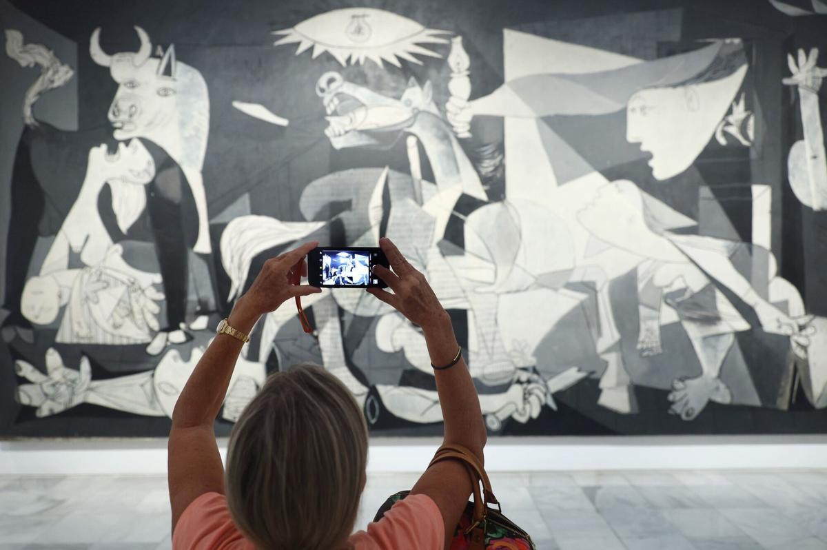 12/09/2022 Una mujer fotografía la obra de Picasso 'Guernica' durante la presentación de los actos conmemorativos del Año Picasso, en el Museo Reina Sofía