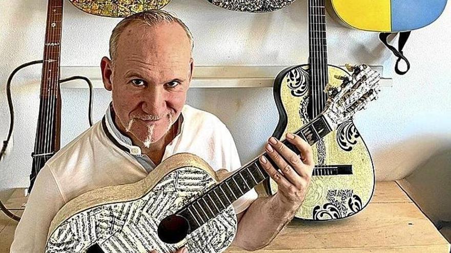 El escritor navarro Hervé Alústiza, con las guitarras rescatadas de contenedores, arregladas y pintadas por el artista Javier Erice.