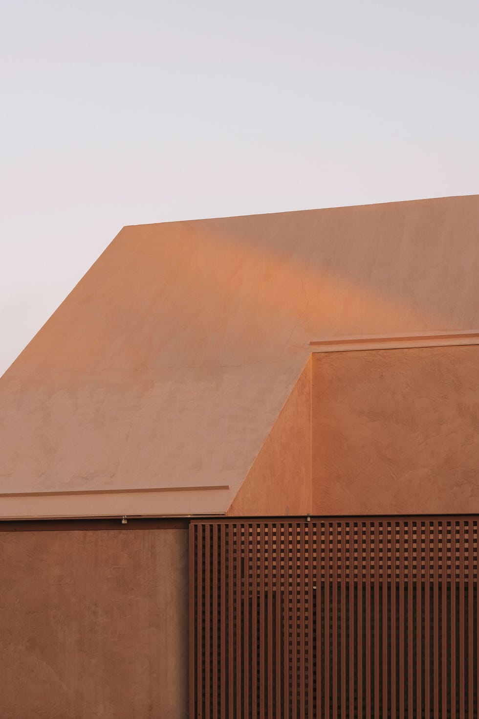 casa de vacaciones una sola planta flota sobre el terreno, tiene un tejado a dos aguas y oculos disenados con un modelo en 3d