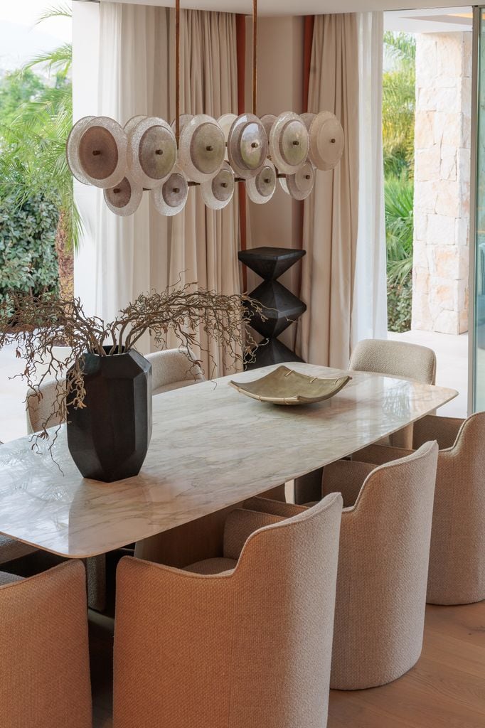 Comedor con mesa de mármol y lámpara escultural