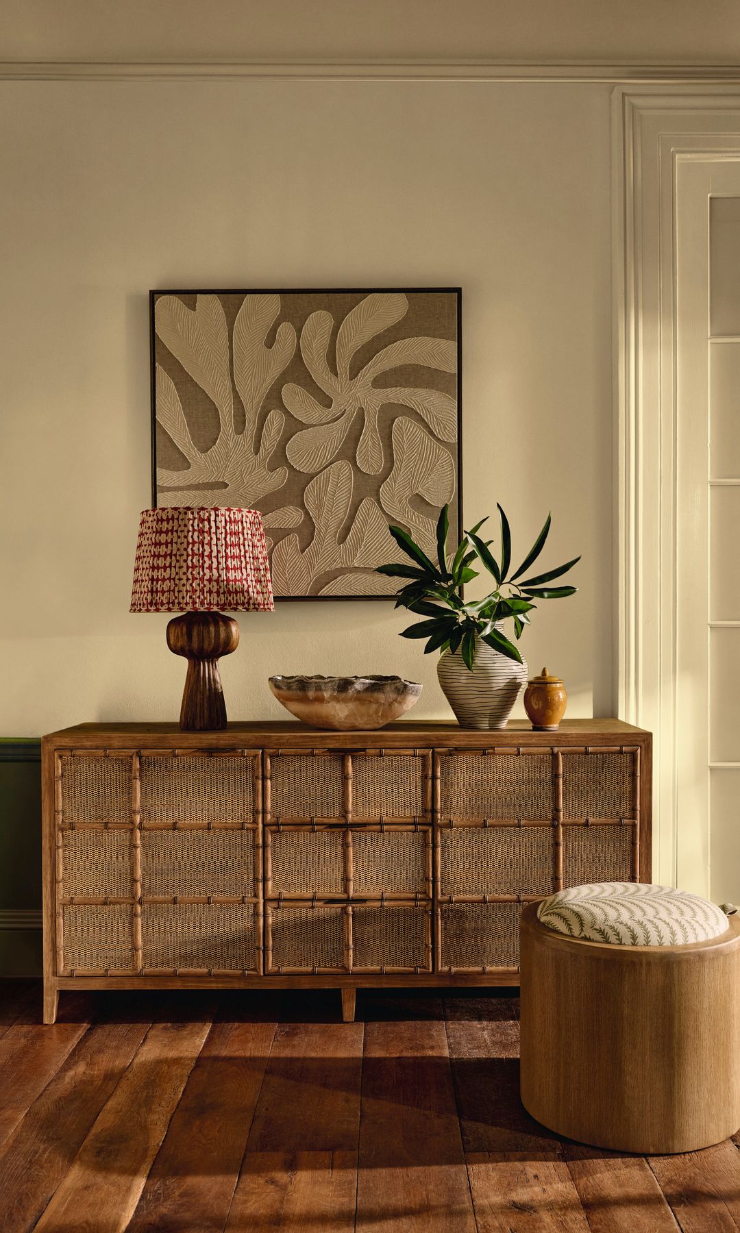 Recibidor con aparador, cuadro en la pared, puff, lámpara de sobremesa, jarrón y vacíabolsillos 