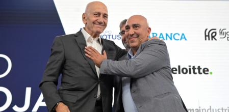 El ex primer ministro israelí Ehud Olmert y el activista palestino Samer Abdelrazzak Sinijlawi se saludan al finalizar la mesa redonda sobre la paz en Gaza durante el Foro La Toja  (MIGUEL RIOPA / AFP)